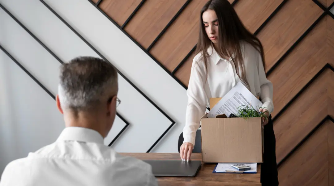 Trabajadora en proceso de salida laboral con caja de pertenencias, caso típico para abogado laboral para trabajadores
